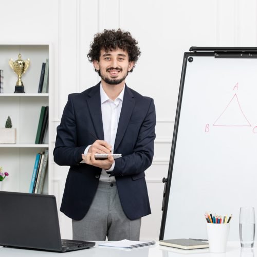 teacher-brunette-instructor-with-computer-suit-whiteboard-classroom-holding-notepad